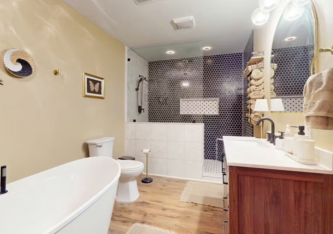 Unwind in your elegant bathroom with a soaking tub, stunning tiled shower, and luxurious amenities for your comfort.