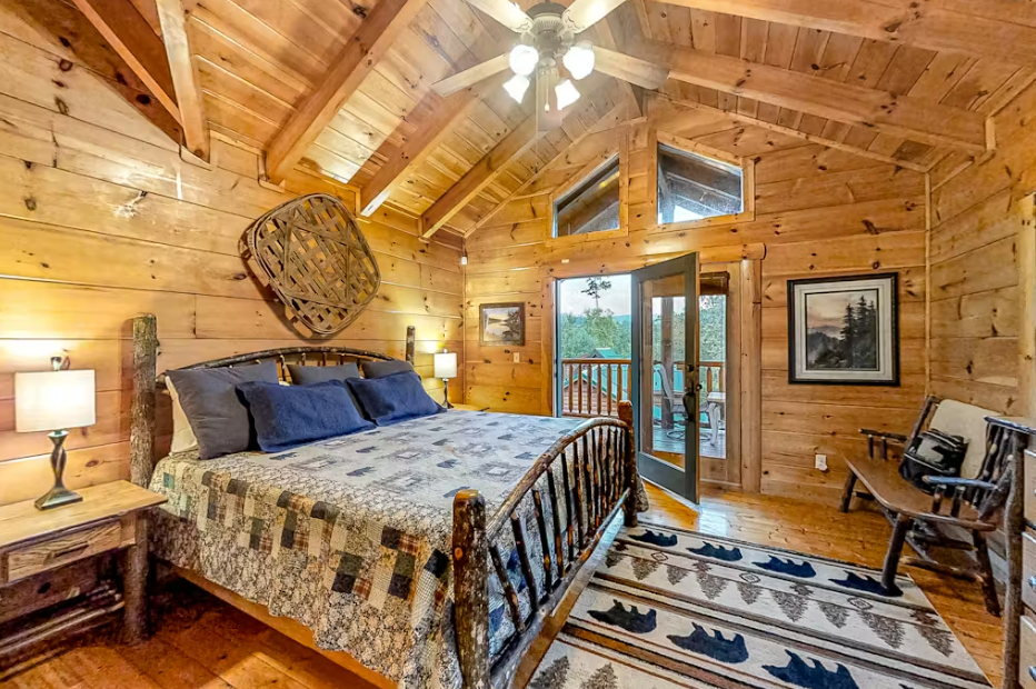 Drift off in your rustic cabin bedroom beneath soaring wooden beams, where cozy quilts and natural charm create your perfect mountain retreat.