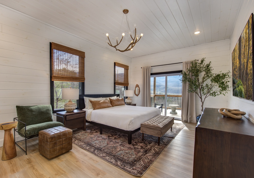Your serene bedroom features rustic elegance with warm wood accents and peaceful lake views from your private balcony.