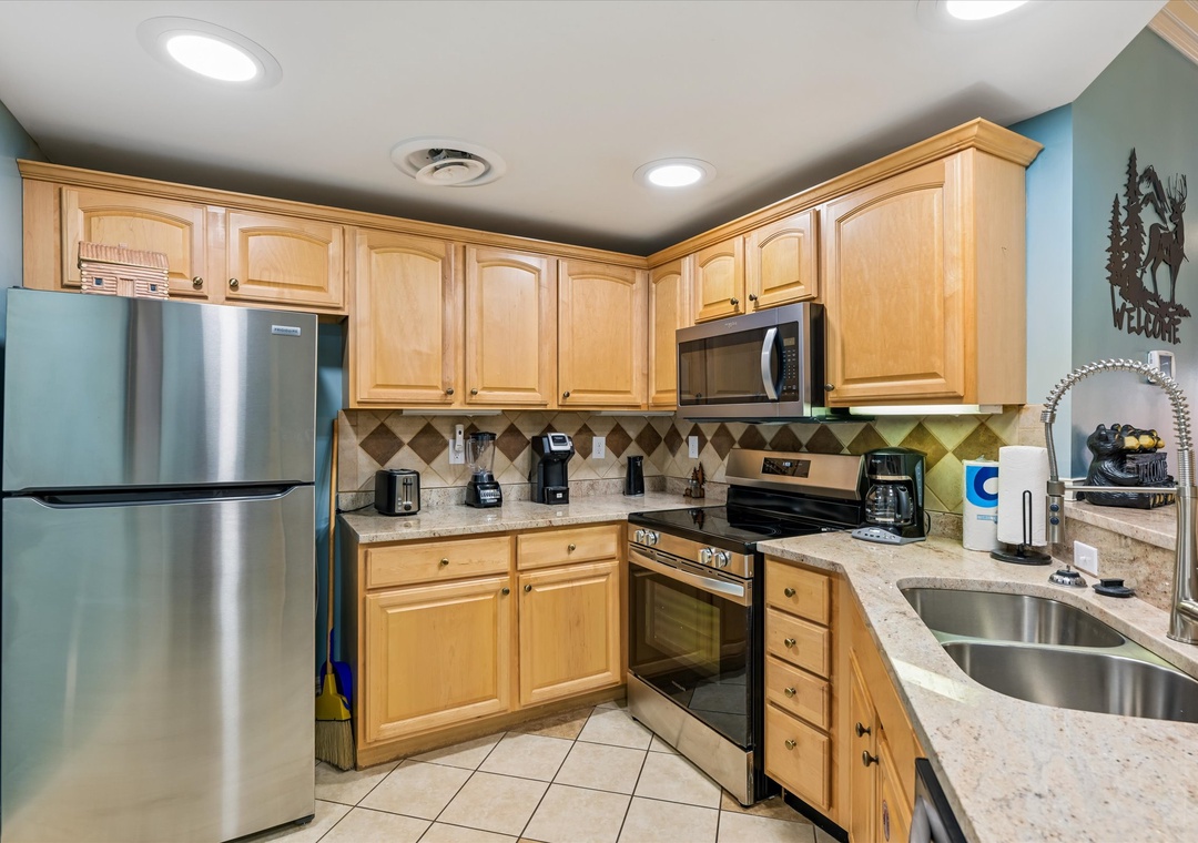 Your fully equipped kitchen invites culinary adventures with granite counters, stainless appliances, and warm wood cabinets creating the perfect cooking sanctuary.