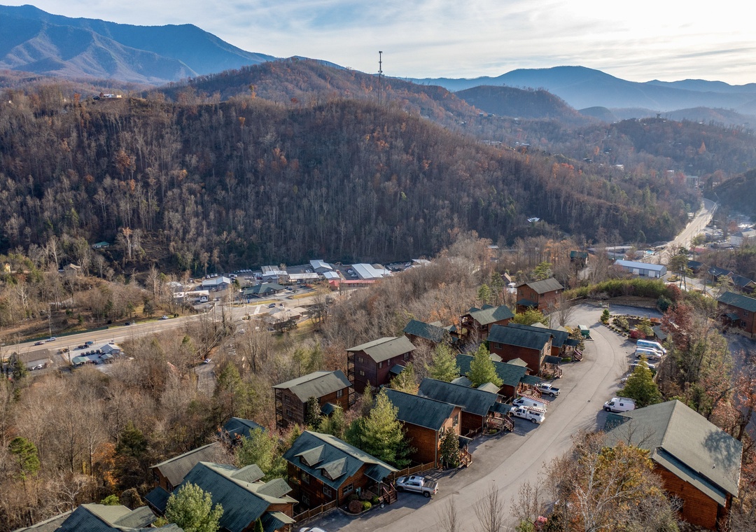 A mountain resort community nestled among forested hills and distant peaks, offering a peaceful retreat surrounded by nature's beauty.