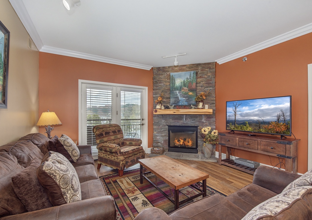 Cozy up in your inviting living room with a crackling stone fireplace, plush seating, and mountain views through French doors.