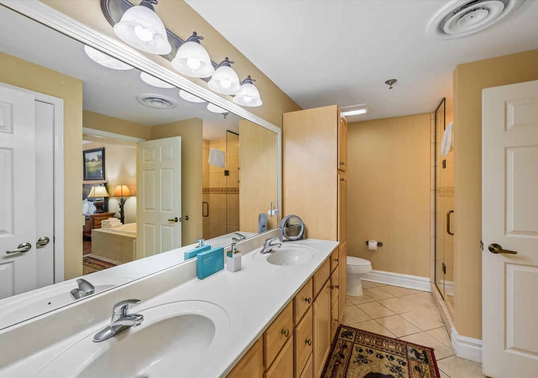 Your spacious master bathroom features dual sinks and warm lighting, creating a serene retreat for your morning routine.