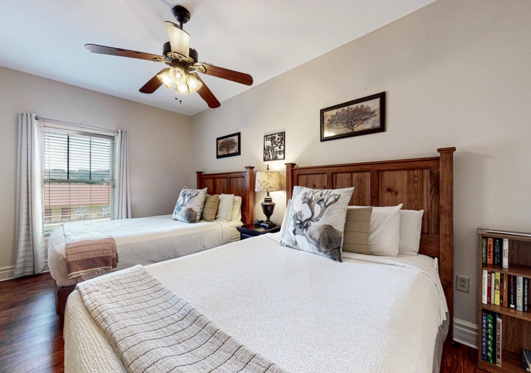 Unwind in your cozy twin bedroom with rustic wood accents, soft linens, and gentle ceiling fan for perfect comfort.