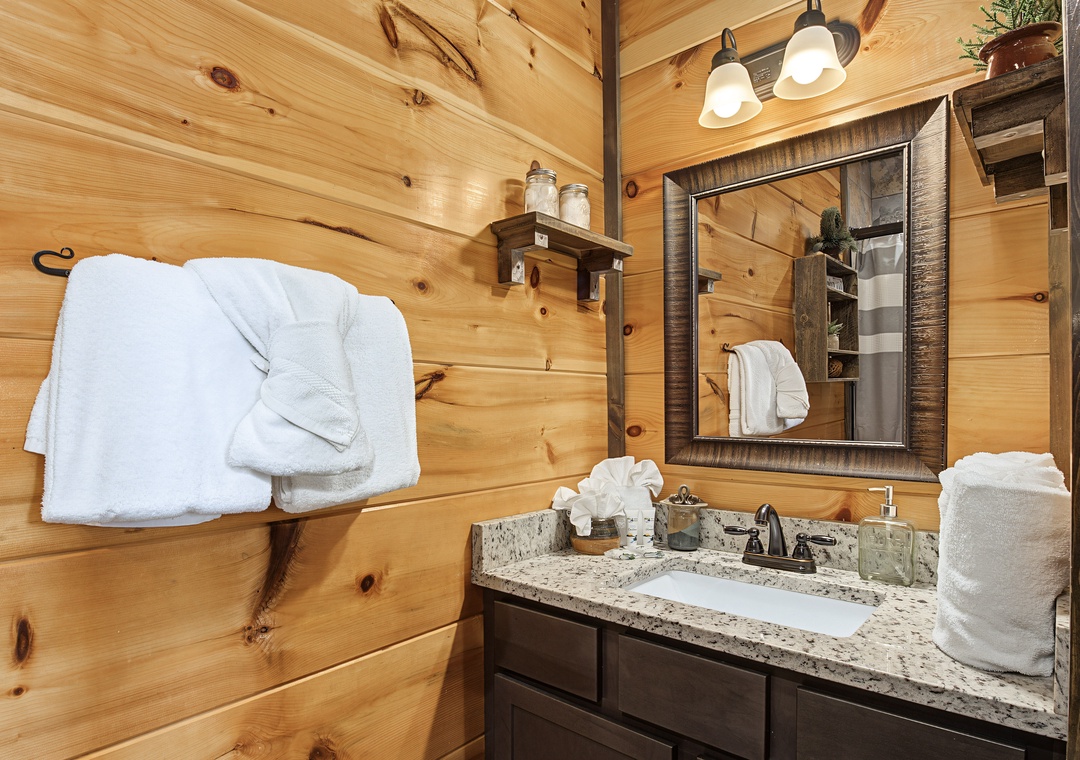Step into your rustic-chic bathroom where warm wood walls meet modern comforts. Fresh towels await, and the granite vanity provides all the space you need to unwind.