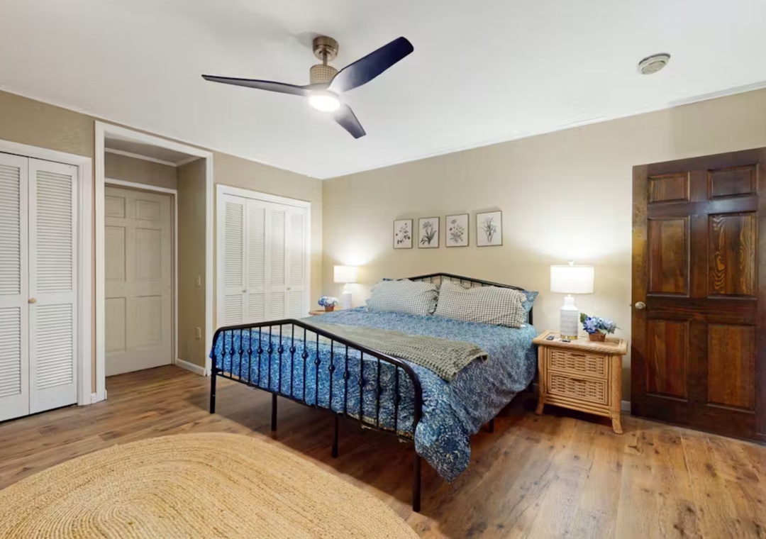 Unwind in your spacious bedroom with hardwood floors, elegant bedding, and a ceiling fan for comfort.