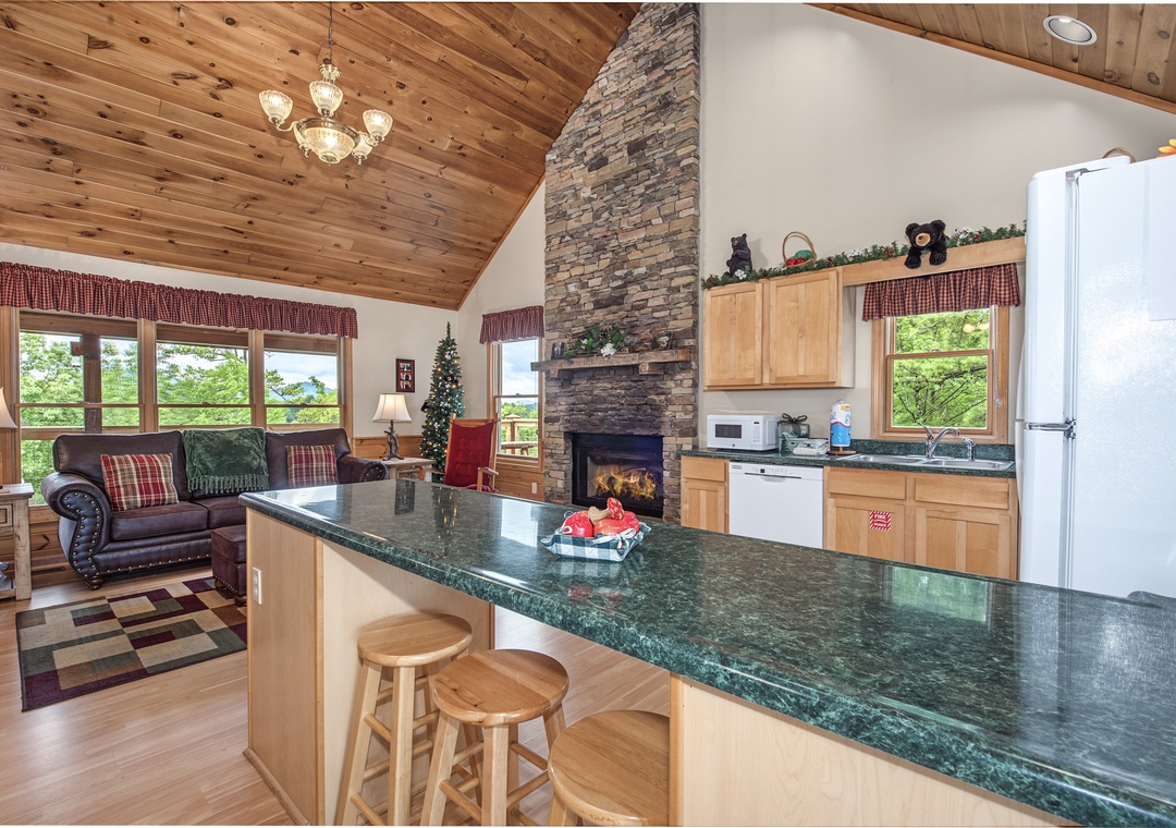 Relax in this open-concept mountain retreat with soaring wood ceilings, a striking stone fireplace, and a spacious kitchen perfect for gathering and creating lasting memories together.