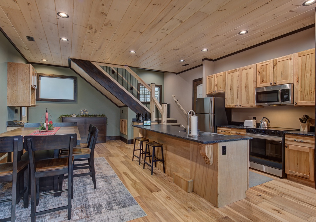Cook memorable meals in your fully equipped mountain kitchen featuring natural wood cabinetry, granite countertops, and modern appliances.