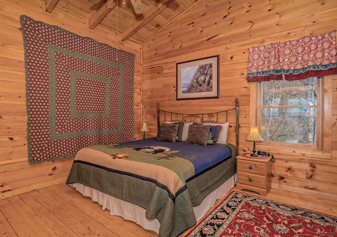 Unwind in your cozy log cabin bedroom with rustic charm, soft quilts, and peaceful forest views through the window.