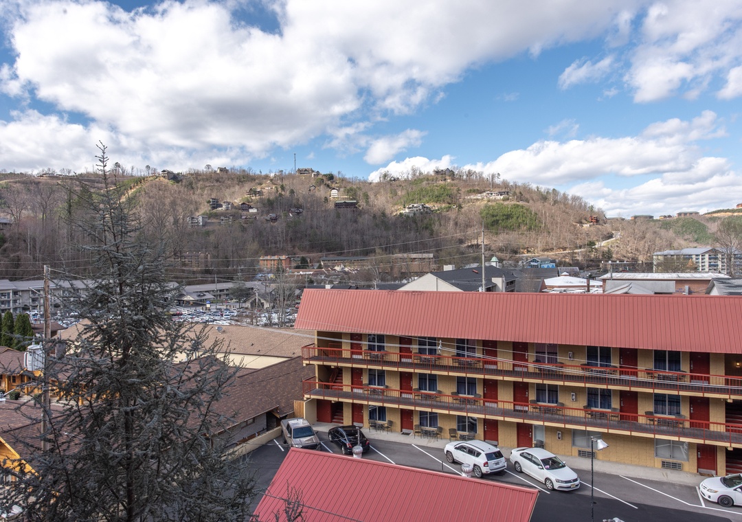 Mountain town setting with multi-story lodging buildings nestled among rolling hills and residential neighborhoods.