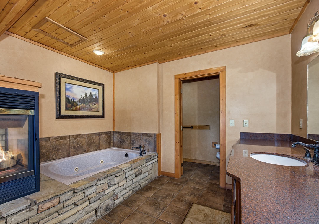 Soak in your private jetted tub beside the cozy fireplace, where warm wood accents and soft lighting create your perfect retreat after a day of adventure.