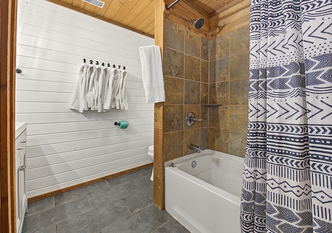 Unwind after a day of adventure in your private bathroom, where rustic wood meets modern comfort. Fresh towels await, and the spacious tub invites you to soak away your cares.