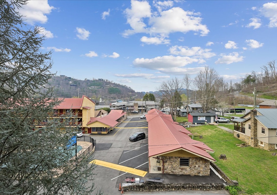 Mountain lodge property sits nestled in scenic valley surrounded by rolling hills and spring greenery.