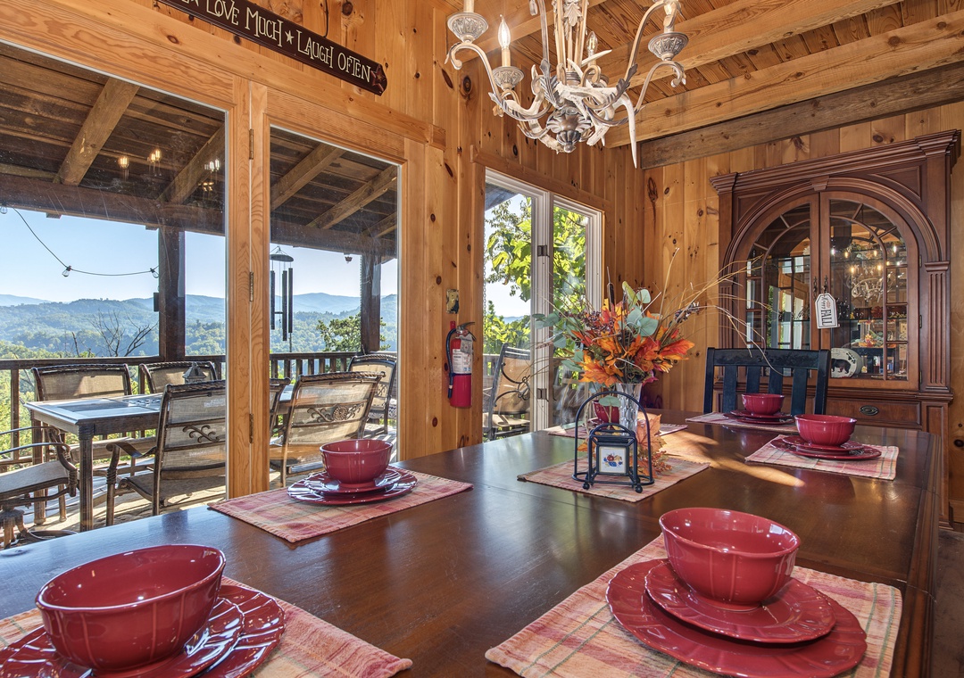 Gather around the cozy dining table where warm autumn tones meet breathtaking mountain vistas through floor-to-ceiling windows. Natural wood beams and an elegant chandelier create the perfect setting for memorable meals with your group.