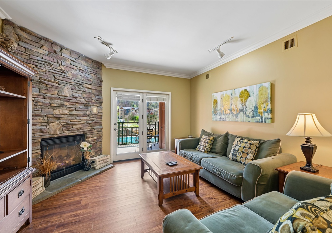 Unwind in your cozy living room, where warm earth tones and a stunning stone fireplace create the perfect retreat for relaxation.