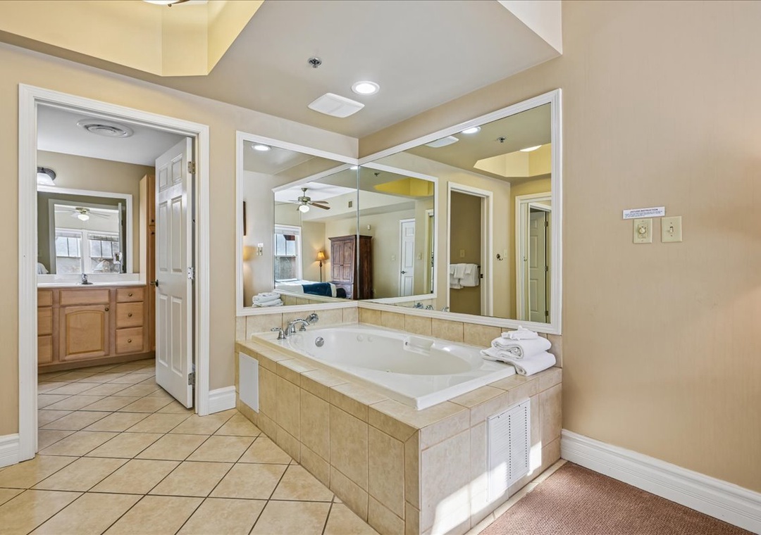 Sink into your private jetted tub surrounded by elegant tile work and spacious mirrors for the ultimate relaxation experience.