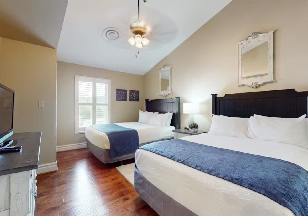 Your spacious room features two queen beds with crisp white linens and elegant blue accents, creating a restful retreat after your adventures.