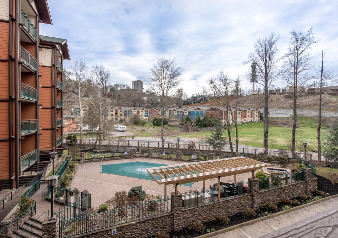 Modern property complex featuring a swimming pool with landscaped grounds and residential neighborhood views in the surrounding area.