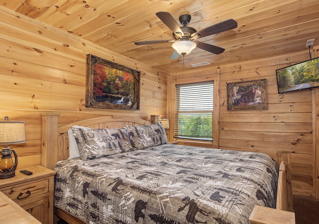 Drift off in this cozy cabin bedroom where rustic charm meets comfort. Natural wood surrounds you, soft bedding invites rest, and a ceiling fan keeps you comfortable year-round.