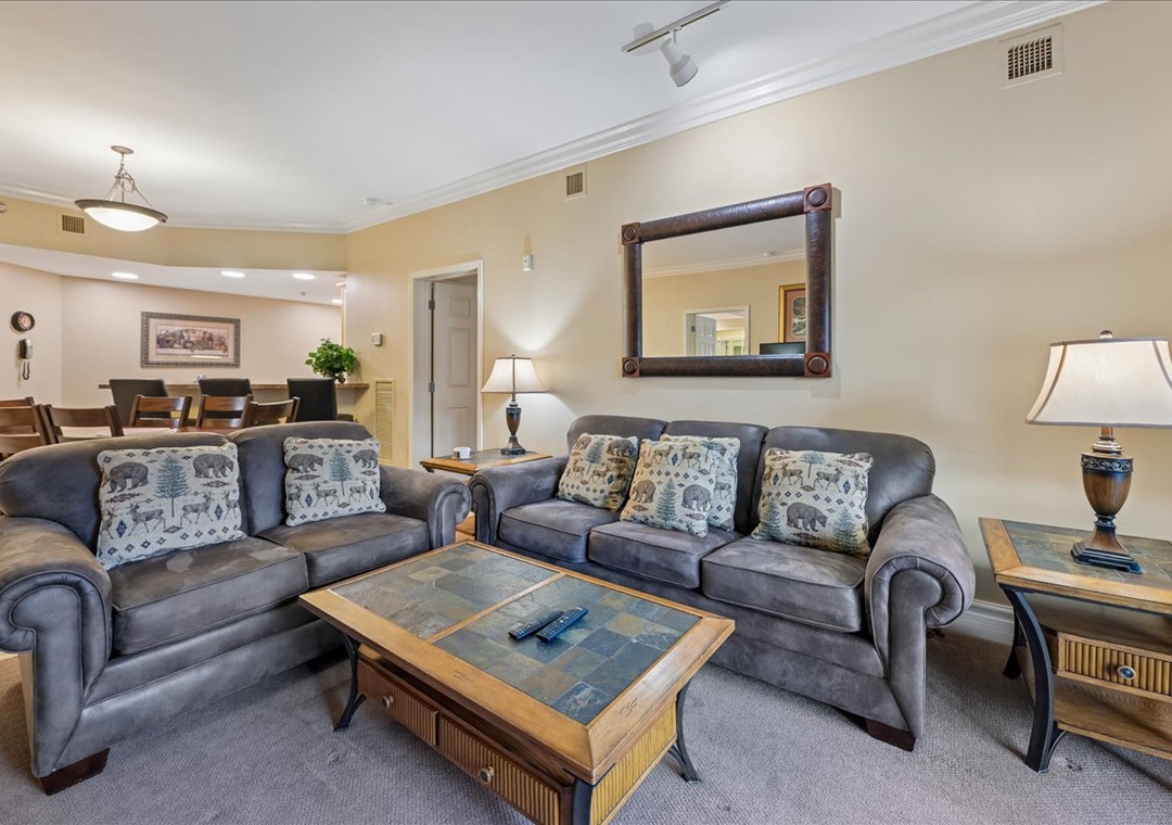 Unwind in your spacious living room with plush blue sofas and rustic-chic decor that feels like home.