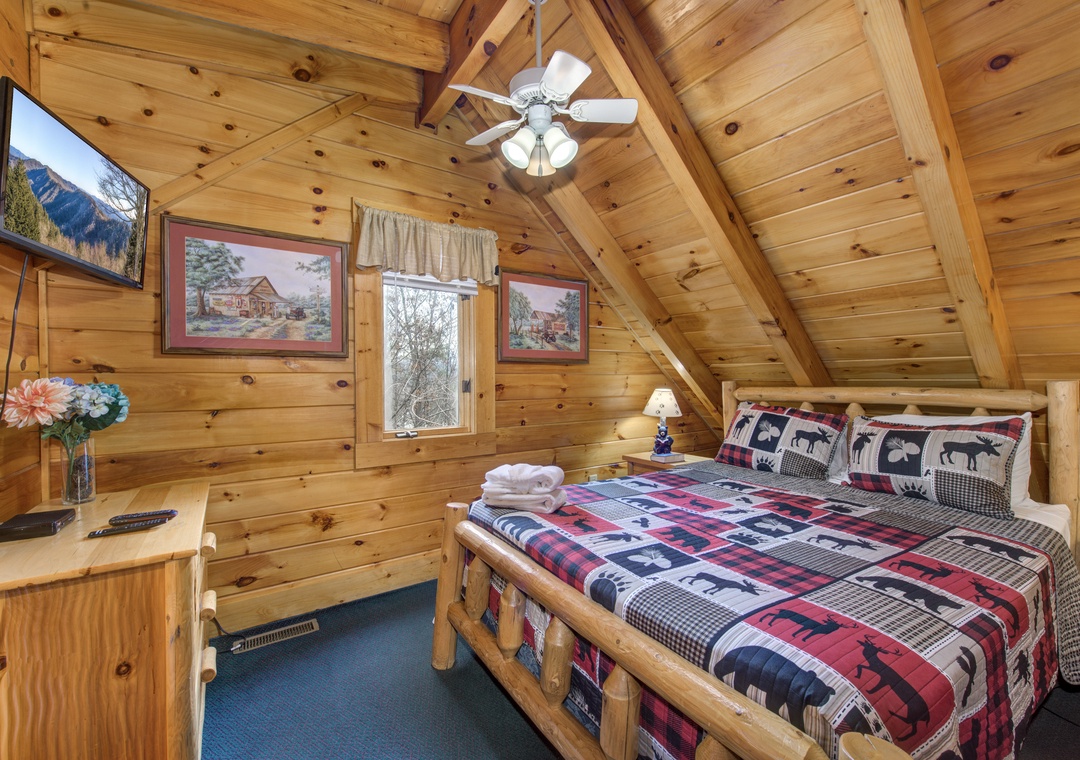 Cozy up in your rustic bedroom with knotty pine walls, comfy log bed, and mountain artwork creating the perfect cabin retreat.