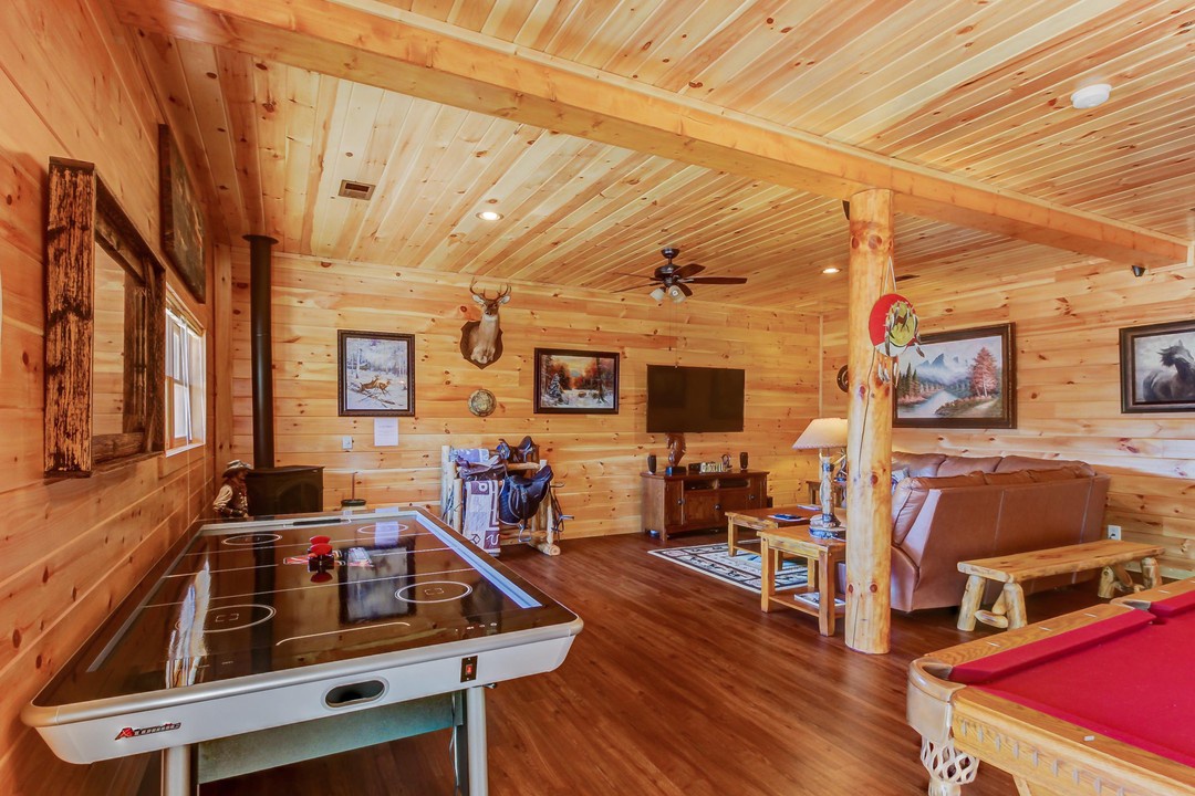 Step into your rustic mountain retreat, where vaulted pine ceilings and cozy furnishings create the perfect setting for laughter-filled evenings. Challenge your family to air hockey or billiards while you unwind in this inviting space.