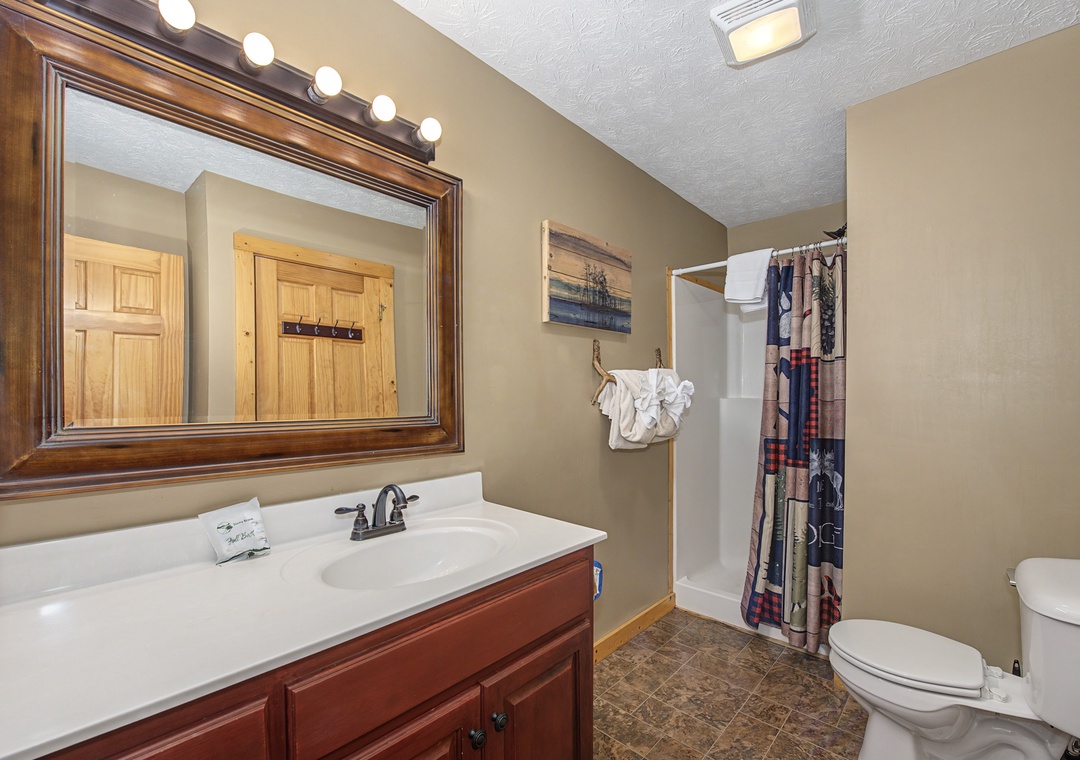 Step into your spacious bathroom with warm wood finishes, bright vanity lighting, and a relaxing shower-tub combo for unwinding.