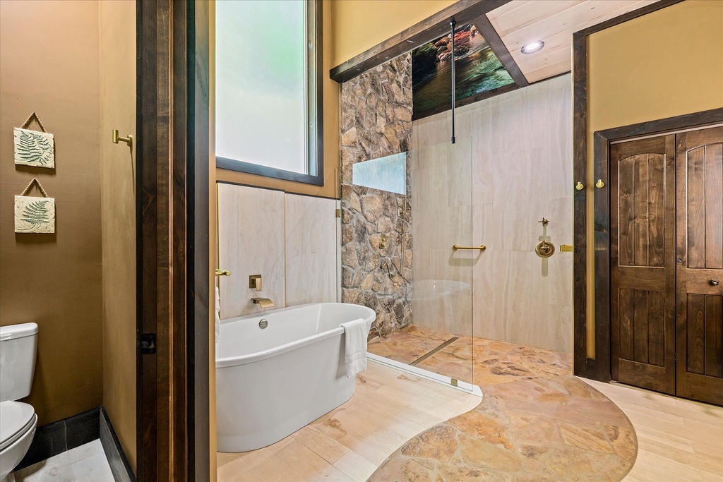 Immerse yourself in luxury with a spa-like bathroom featuring a soaking tub, spacious walk-in shower with natural stone accents, and warm, inviting finishes that make relaxation effortless.