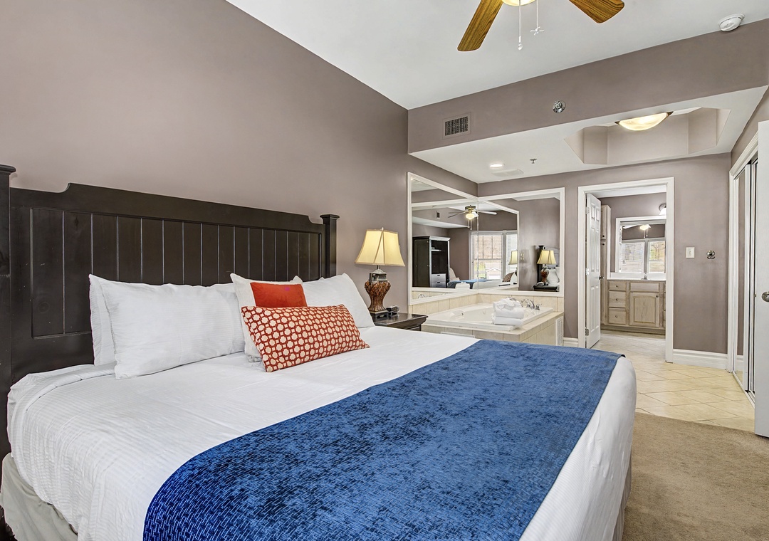 Relax in your spacious bedroom featuring a plush king bed and romantic jacuzzi tub, perfect for unwinding after exploring.