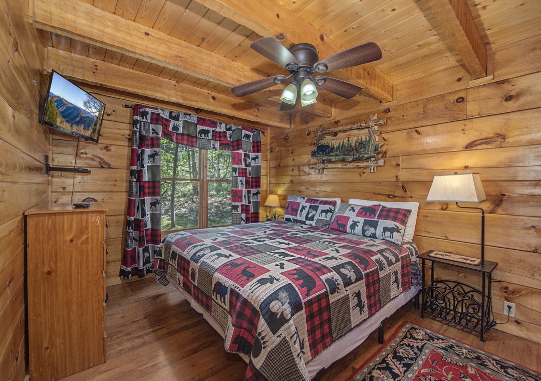 Your cozy log cabin bedroom envelops you in rustic warmth with rich wood walls and charming wilderness-themed bedding perfect for peaceful mountain getaways.