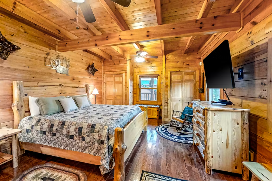 Unwind in your rustic log cabin bedroom featuring authentic wood beams, cozy furnishings, and modern amenities for the perfect mountain retreat.