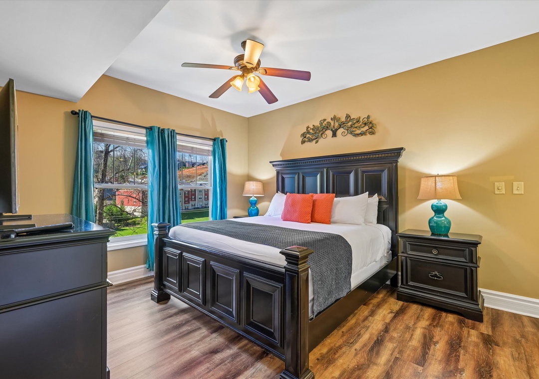 Your elegant bedroom features rich hardwood floors, a ceiling fan for comfort, and garden views through bright windows.