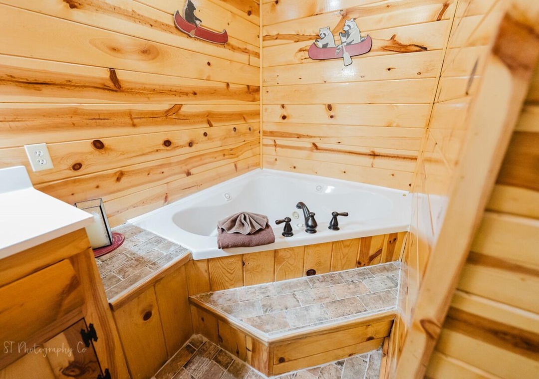 Unwind in your rustic bathroom with a cozy soaking tub surrounded by warm pine walls and charming woodland details that bring the outdoors in.