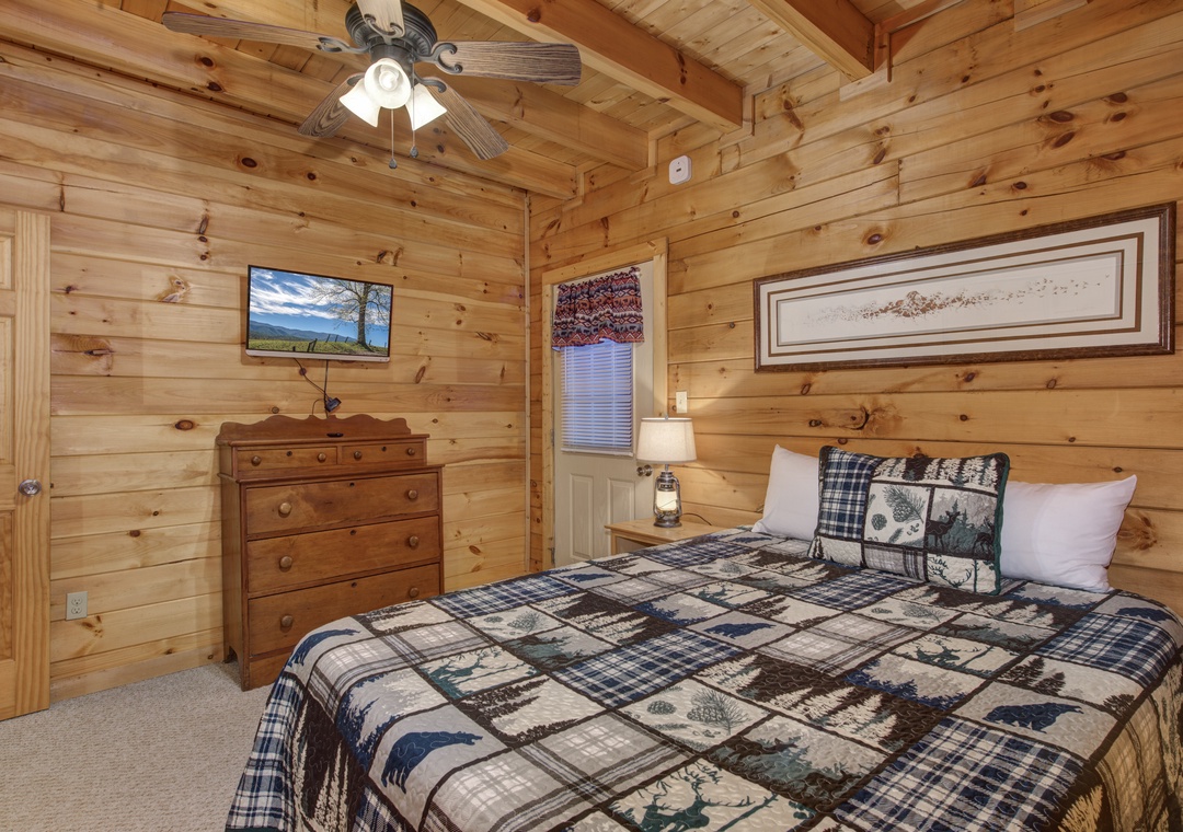 Sleep peacefully in your cozy log cabin bedroom with rustic charm, plaid quilts, and mountain views on TV.