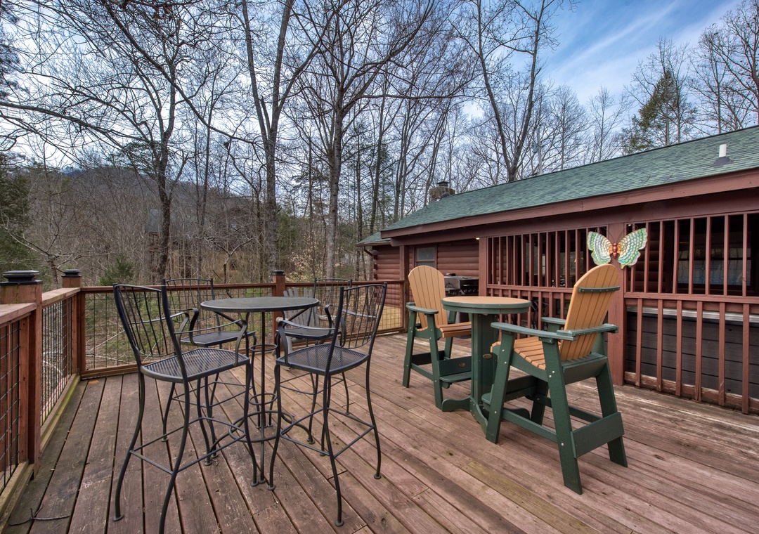 Step onto your private deck where mountain air meets comfort. Savor morning coffee at the bistro table or unwind in colorful Adirondack chairs surrounded by forest serenity.