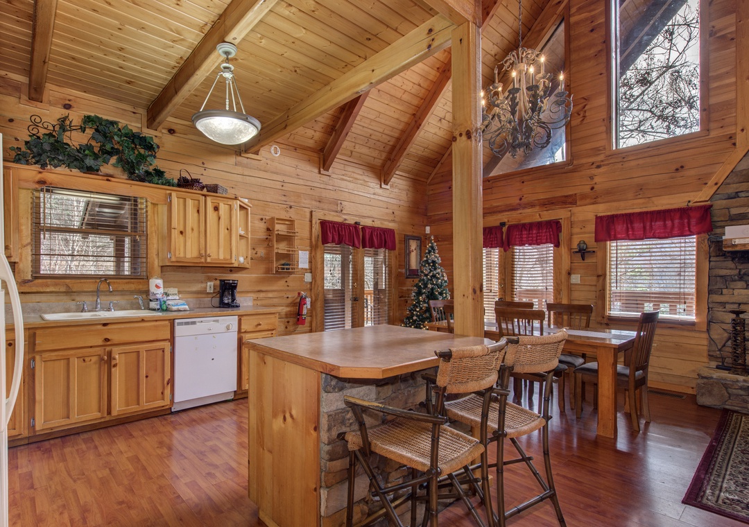 Gather around your rustic kitchen island where warm wood tones and soaring cathedral ceilings create the perfect space for morning coffee.