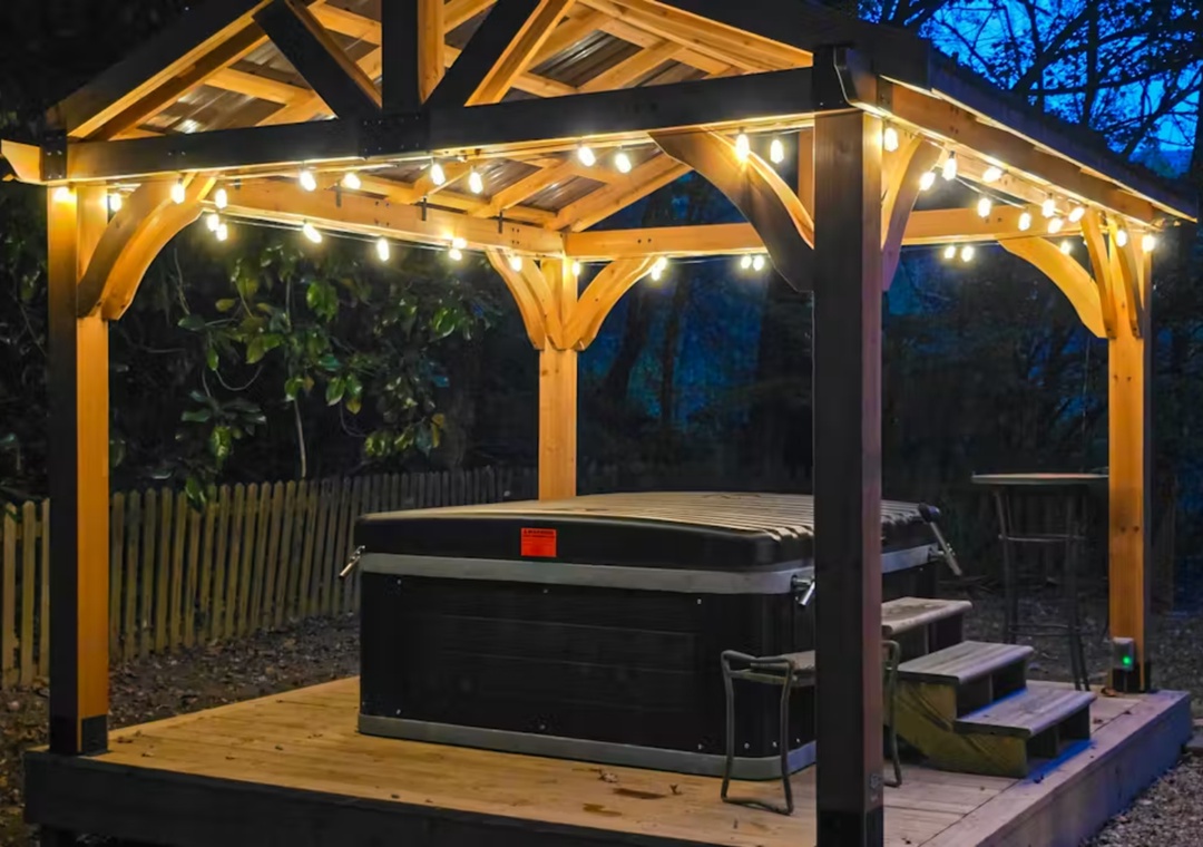 Soak under twinkling lights in your private hot tub, surrounded by peaceful garden ambiance for the perfect evening retreat.