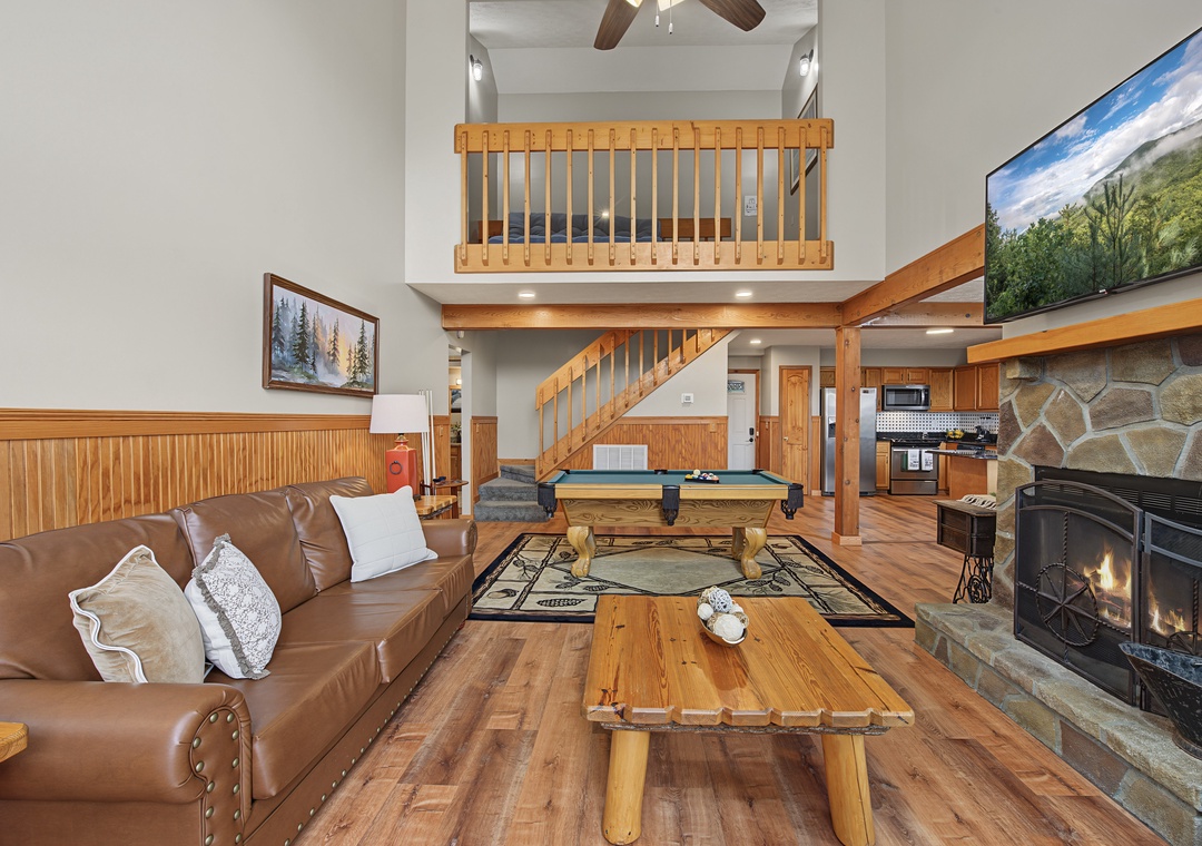 Sink into the leather couch and feel the warmth of the stone fireplace while enjoying your spacious open-concept retreat. The soaring ceilings and rustic wood accents create a cozy mountain getaway vibe.