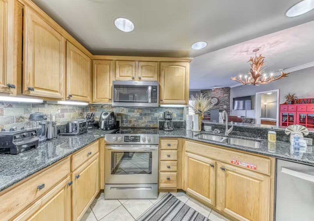 Your fully equipped kitchen features granite countertops, stainless steel appliances, and warm wood cabinets for all your culinary adventures.