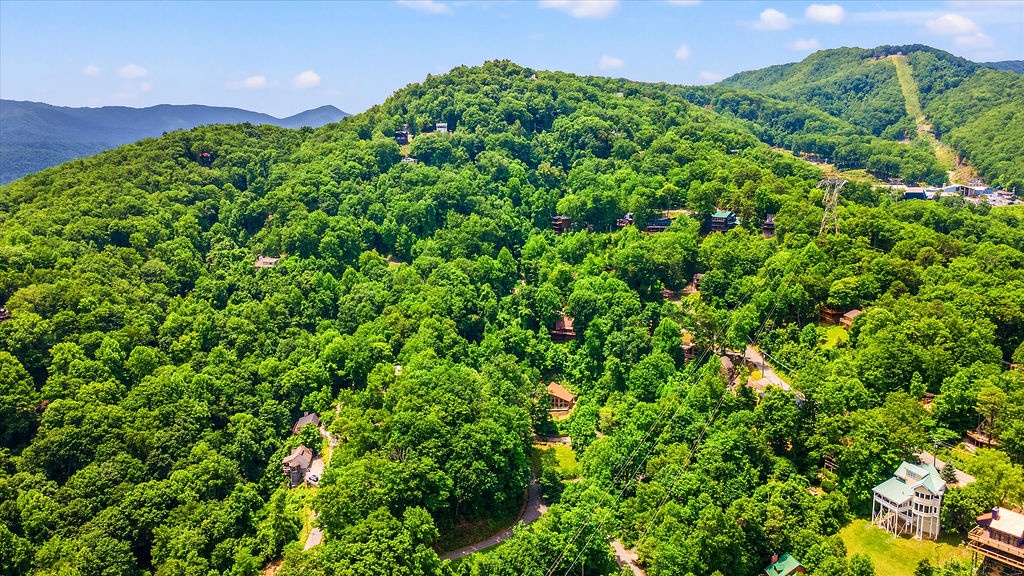 An aerial view of the property nestled within lush, forested mountains, showcasing the natural landscape and peaceful mountain setting.