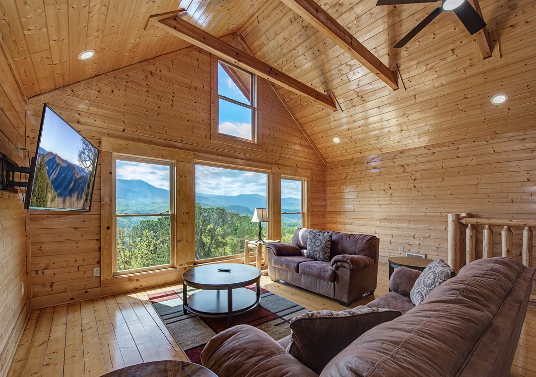 Sink into plush sofas while soaking up breathtaking mountain vistas through floor-to-ceiling windows in this warm, rustic living space.