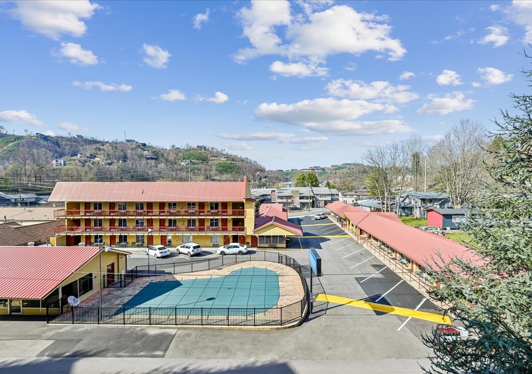 Mountain-surrounded property with outdoor pool, ample parking, and convenient hillside location in scenic valley setting.