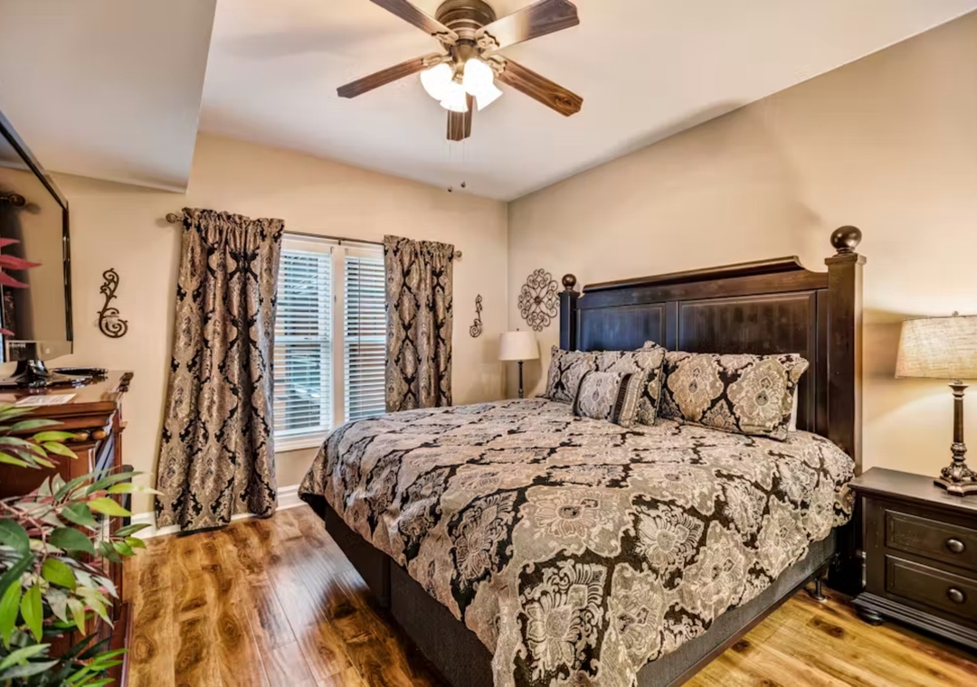 Your spacious bedroom features elegant furnishings and a ceiling fan for comfort.