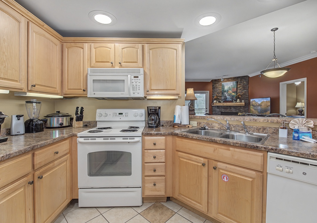 Your fully equipped kitchen invites culinary adventures with granite counters, modern appliances, and warm wood cabinetry creating the perfect cooking space.