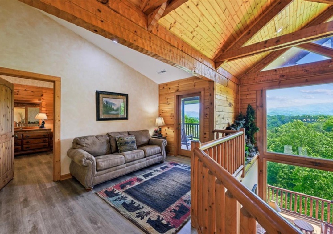 Unwind in your cozy loft retreat with soaring cathedral ceilings and warm wood accents. Sink into the plush sofa as natural light pours through expansive windows, framing sweeping mountain views that bring the outside in.
