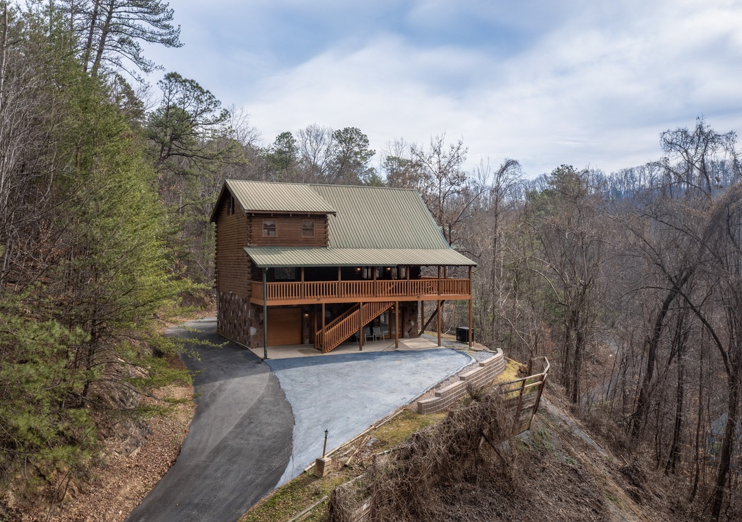 Rustic mountain cabin perched among rolling hills with spacious parking and forested surroundings.