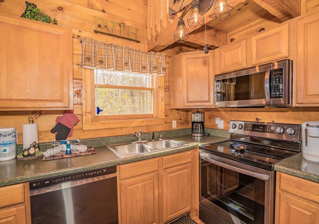 Your cozy cabin kitchen awaits with warm wood cabinetry, modern stainless appliances, and rustic charm for memorable meal preparation.