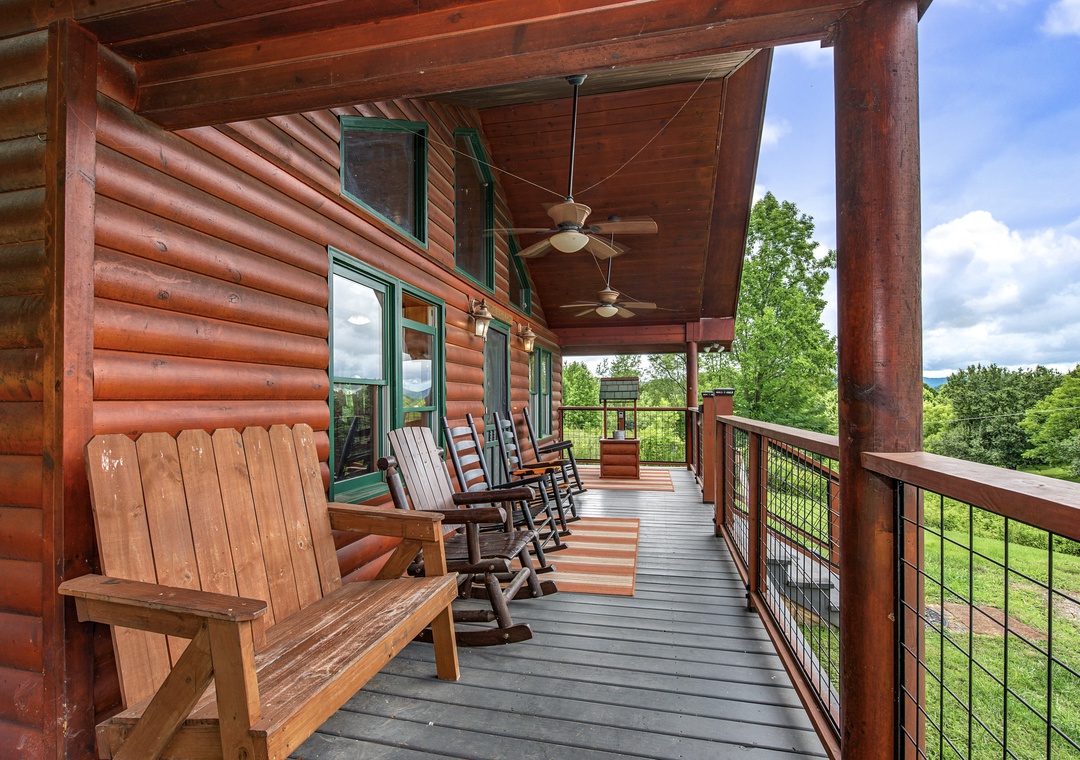 Settle into your covered porch with rocking chairs and a rustic bench, where ceiling fans keep you comfortable while you take in sweeping mountain and forest views—perfect for morning coffee or evening relaxation.