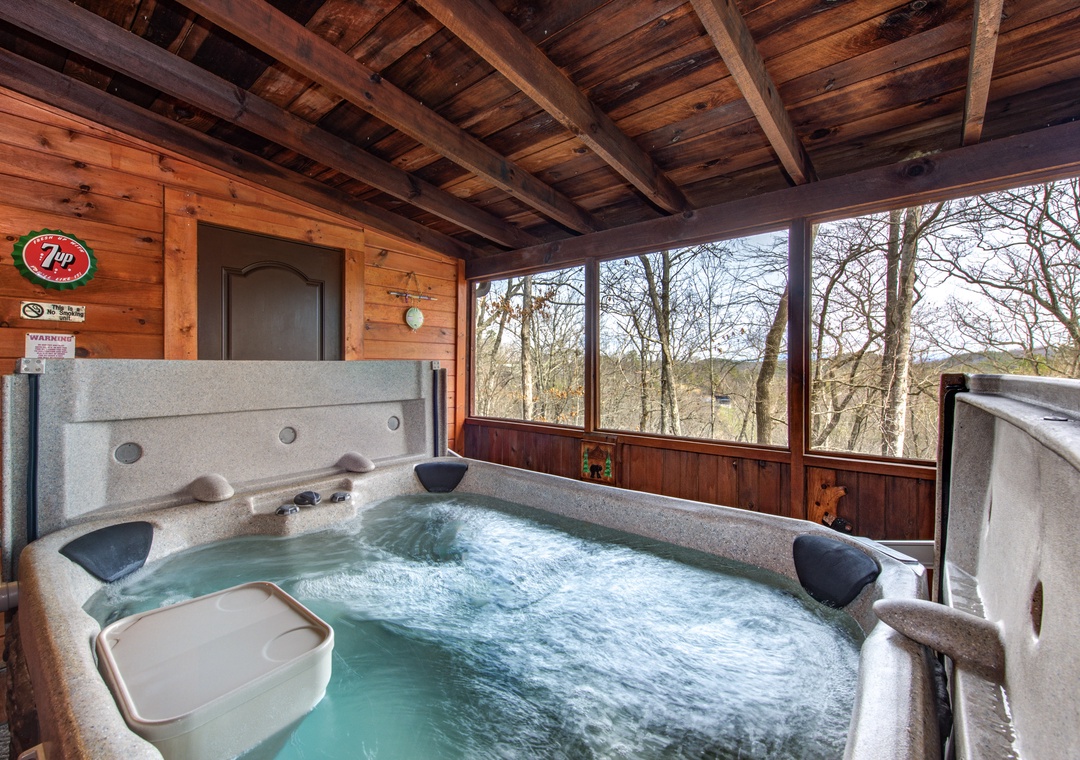 Soak in your private hot tub while enjoying panoramic forest views through floor-to-ceiling windows in this cozy covered retreat.