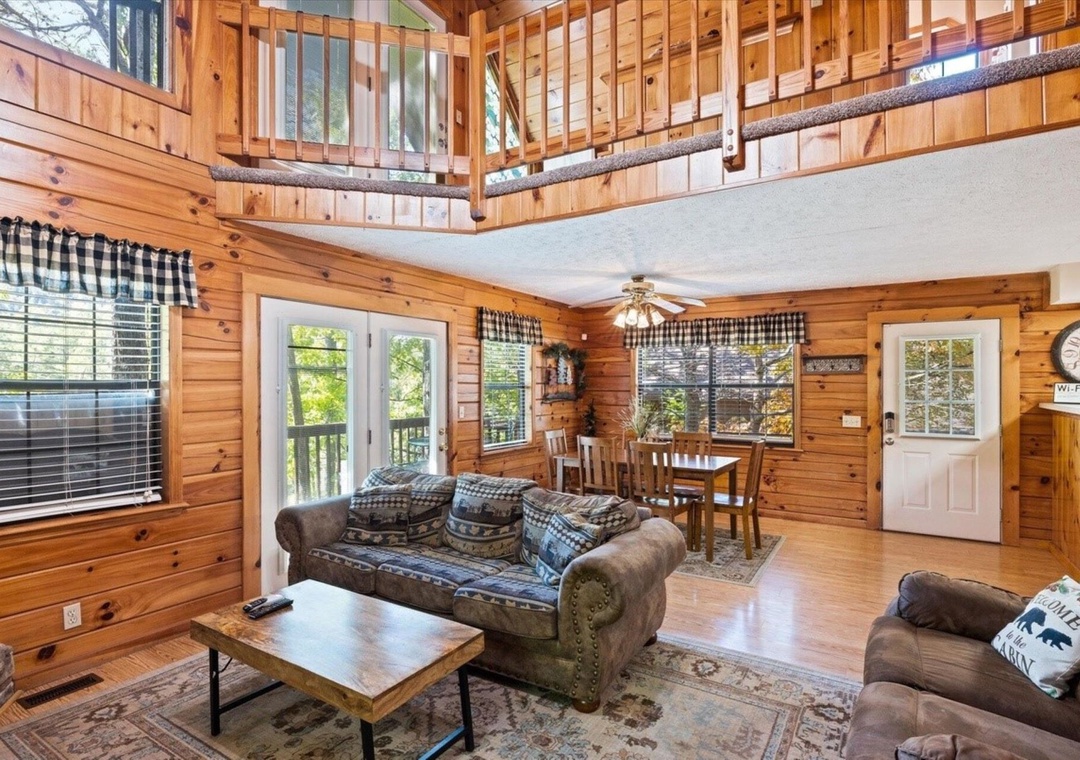 Cozy up in your rustic cabin retreat with warm wood walls, comfy seating, and soaring ceilings that create the perfect mountain getaway atmosphere.